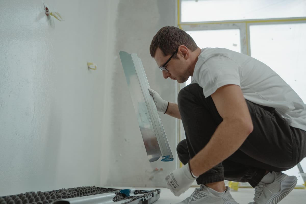 Artisan plombier travaillant sur une rénovation salle de bain à budget économique