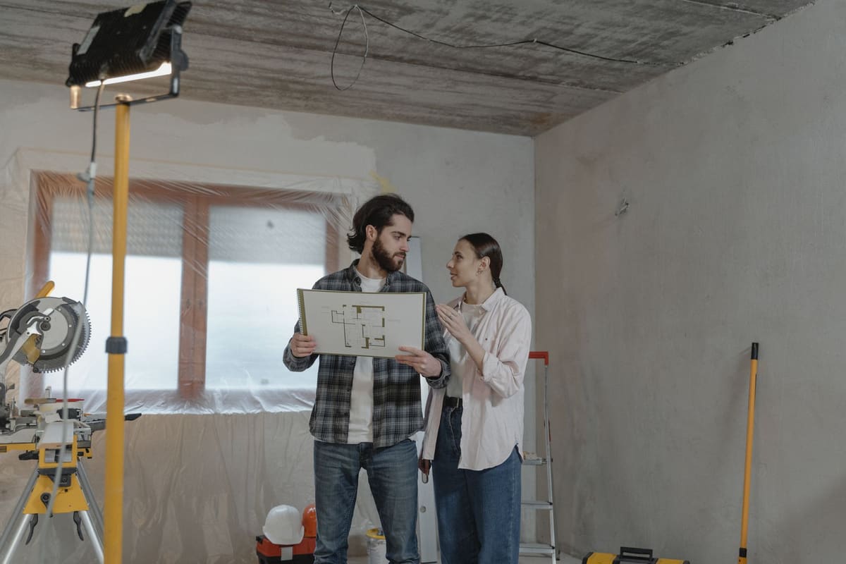 Couple examinant un devis de rénovation salle de bain avec un artisan