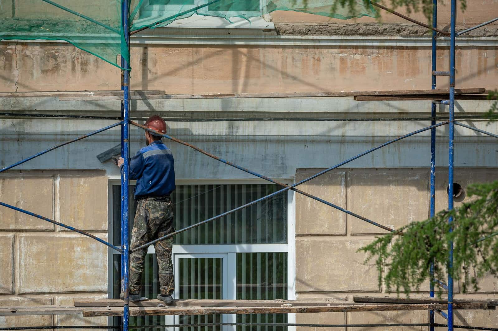 Chantier de rénovation énergétique avec pose d'isolation sur une façade de maison